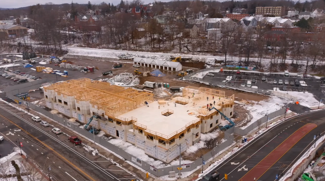 aerial view of a multifamily building under construction in the winter with snow on the ground